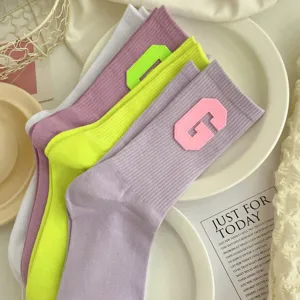 Stylish women rib knit mid-tube socks with bold letter G patch for daily casual wear.
