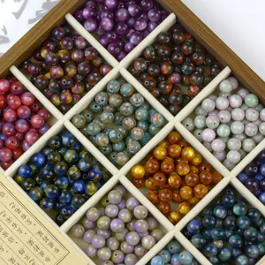 Close-up of colorful resin beads in grid storage box, perfect for DIY jewelry making details.