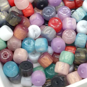 Close-up detail of colorful resin barrel beads with marbled gilded finish for DIY crafts.