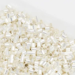 Gros plan de tubes à sertir argentés et de perles d'espacement pour les bijoux faits maison.
