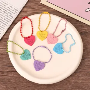 Llaveros coloridos de metal con cadena de cuentas de corazón y dijes para bolsos.