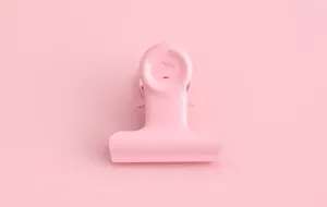 Pinza de carpeta de metal rosa para organizador de papelería de oficina y manualidades DIY.