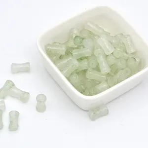 Detailed shot of green bamboo glass beads, tie-dye style loose beads for handmade DIY bracelets.