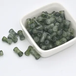 Close-up view of green glazed bamboo shaped spacer beads for handmade DIY jewelry making.