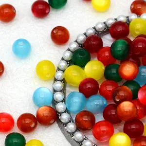 Detailed close-up of colorful jelly resin beads and decorative pearl metal ring for crafts.