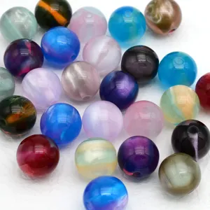 Gros plan de perles rondes œil de chat colorées, parfaites pour la création de bijoux DIY.