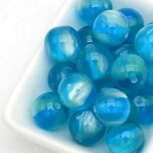 Gros plan sur des perles œil-de-chat gelée bleue de 12 mm, idéales pour bijoux et breloques DIY.