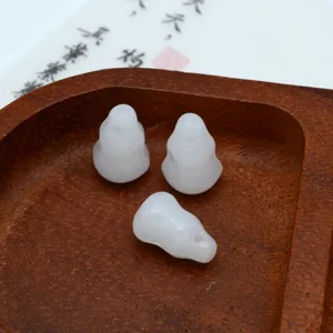 Detalle en primer plano de pequenos colgantes de calabaza de vidrio blanco para DIY.