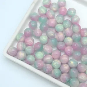 Close-up detail of gradient pink and mint green resin beads, perfect for DIY jewelry craft.