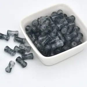 Close-up detail of gray glass bamboo beads with ink wash texture and sparkling gold speckles.