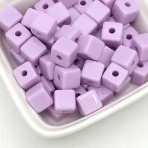 Gedetailleerd overzicht van pastelpaarse acryl kubus kralen, perfect voor DIY sieraden maken.