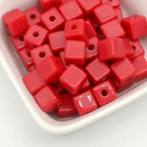 Detailopname van rode acryl vierkante kubus kralen met gat voor DIY sieraden maken.