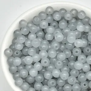 Close-up detail shot of translucent grey 4mm glass seed beads in bowl for DIY jewelry.