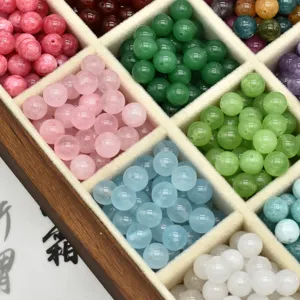 Primo piano dettagliato di perle di cristallo in pietra naturale colorata in una scatola di legno.
