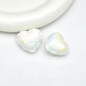 Close-up detail of iridescent UV acrylic heart beads with embossed text for DIY phone charms.