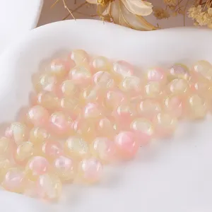 Detailed shot of resin round beads with fine glitter, pink and yellow DIY jewelry making accessories.