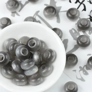 Close up view of grey resin cat eye abacus beads, perfect for DIY jewelry and crafts.