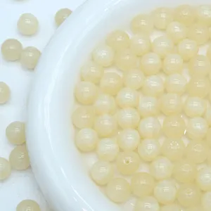 Detailed close-up shot of light yellow starry mermaid resin beads for DIY jewelry making.