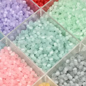 Detailed close-up of 4mm pastel cat eye glass seed beads in a clear storage box for DIY crafts.