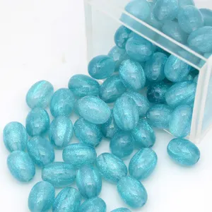Gros plan détaillé de perles ovales en résine bleue scintillante pour création de bijoux.