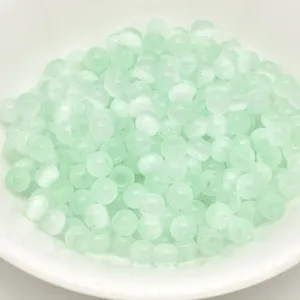 Close-up of 4mm mint green brushed cat-eye glass beads, perfect for DIY jewelry and crafts.