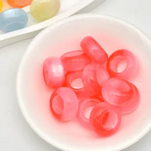 Primo piano di perline ad anello occhi di gatto rosa, perfette per la creazione di gioielli.