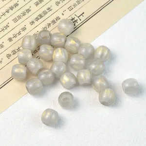Detail shot of translucent grey barrel beads with gold glitter texture for DIY jewelry making.