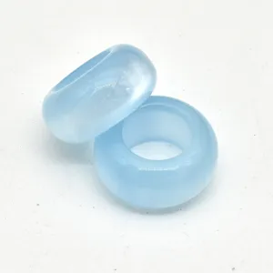 Primo piano dettagliato di perline ad anello azzurre, superficie liscia per gioielli fai da te.