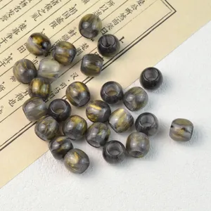 Detail shot of black and gold marbled barrel loose beads for DIY jewelry making.