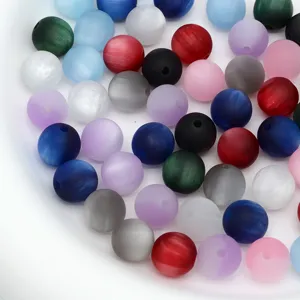 Vue détaillée de perles rondes en œil de chat givré mat pour la fabrication de bijoux de bricolage.