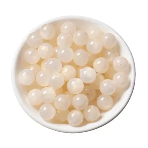 Detailed close-up shot of creamy white resin round beads in a bowl for handmade DIY jewelry making.
