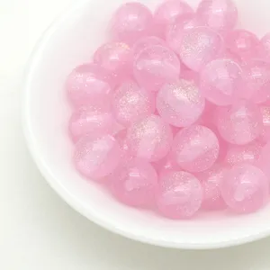 Pink glitter jelly resin round beads detail, macro shot of sparkling DIY jewelry loose beads.