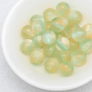 Detailed close-up of jelly-colored marbled beads, green and yellow round loose beads for DIY.