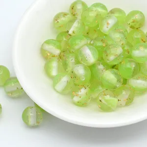 Closeup detail of glittering green resin beads with gold foil flakes for DIY handmade jewelry crafts.