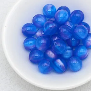 Close-up detail of glossy blue cat's eye beads in a white bowl, perfect for diy jewelry craft.