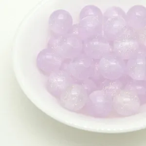 Close-up detail of light purple glitter resin beads, sparkling DIY craft decorative beads.
