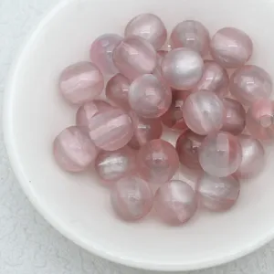 Pink cat eye loose beads detail shot, smooth surface and glowing light band for handmade jewelry.