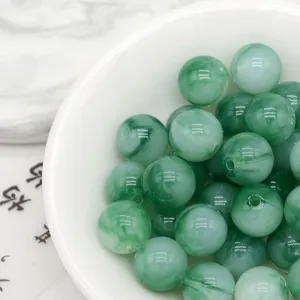 Close-up detail of green tie-dye acrylic beads, imitation jade loose beads for DIY jewelry crafts.