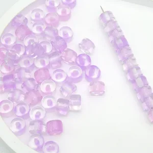Vista dettagliata di perline a barilotto in resina glitterata viola da 8mm per gioielli DIY.