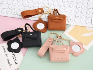 Gedetailleerd overzicht van mini PU lederen tas sleutelhanger met spiegel en oordopjeshoesje.