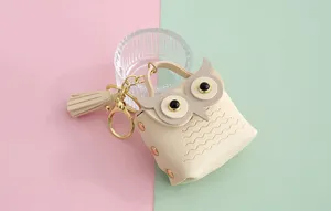 Detalle en primer plano del mini monedero búho de cuero PU con llavero y borla elegante.