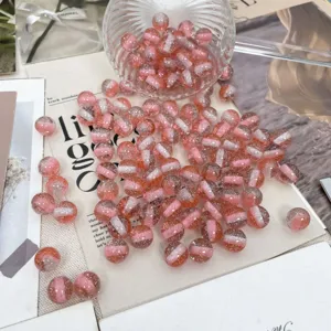 Dettaglio perline in resina glitterata rosa, perle tonde sfumate per gioielli fai da te.