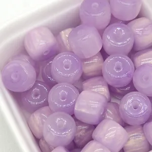 Purple resin barrel beads macro detail showing glossy gradient color and smooth drilled holes.