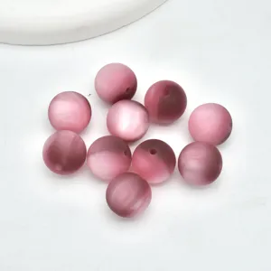 Primo piano di perline occhio di gatto rosa opaco glassato per accessori fai da te.