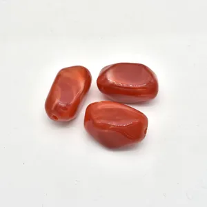 Close-up detail of irregular red imitation stone acrylic beads for DIY handmade jewelry accessories.