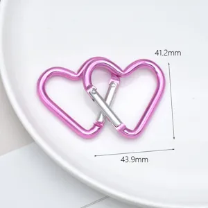 Close-up detail of pink heart shaped metal carabiner hook for DIY crafts and accessories.
