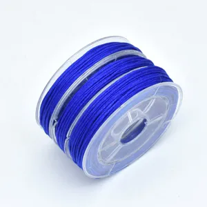 Close-up detail of royal blue 72 jade cord on a clear spool for DIY jewelry crafting.