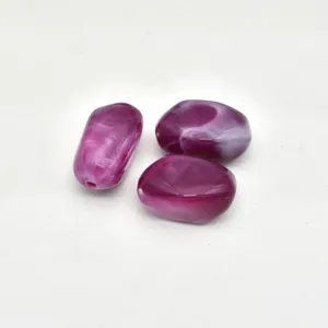 Close-up of purple swirled acrylic beads with pre-drilled hole for DIY jewelry making crafts.