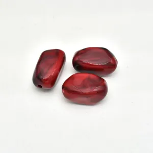 Closeup detail of red marbled acrylic irregular stone beads for DIY jewelry making.