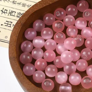 Pink glass cat's eye beads detail shot, perfect for DIY jewelry making and bracelets.